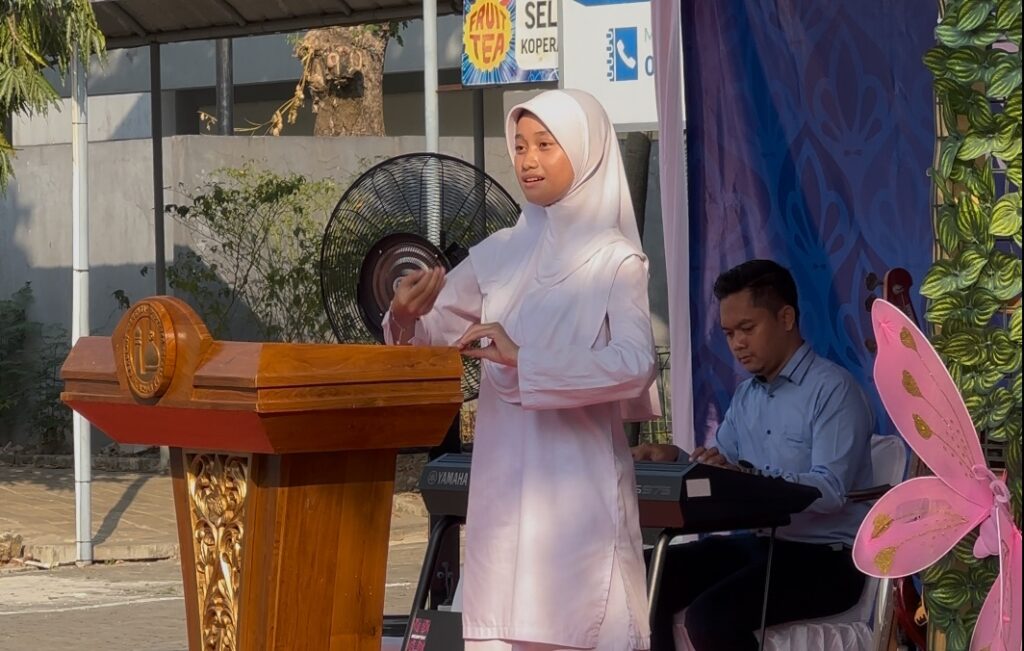 menyanyikan Lagu Indonesia Raya dan Mars YPI (Yayasan Pesantren Islam Al Azhar). Lagu tersebut dibawakan oleh Naidra, murid SMP Islam Al Azhar 16 Cikarang