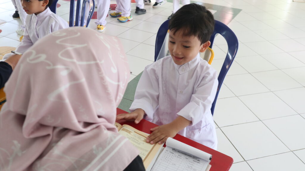 Murid TK Islam sedang berinteraksi dengan guru saat kegiatan belajar di kelas.