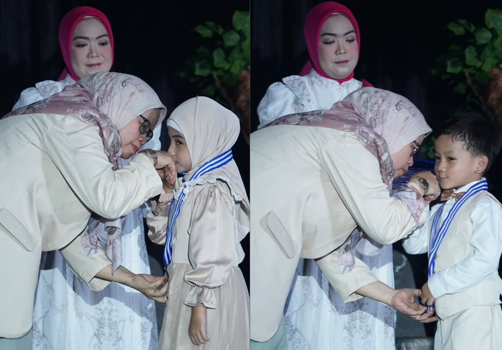 Seorang guru memberikan pelukan hangat dan mengalungkan medali kelulusan kepada murid perempuan dan laki-laki TK Islam Al Azhar 12 Cikarang.