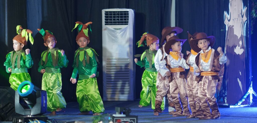 Murid TK menampilkan drama teaterikal menggunakan ragam kostum Nusantara dan kostum pohon.