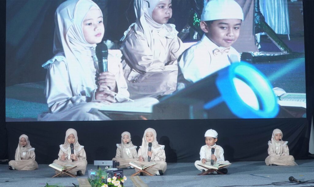 Murid TK Islam Al Azhar 12 Cikarang duduk bersila sambil melantunkan ayat suci Al-Qur'an pada acara Tasyakur Al-Qur'an.