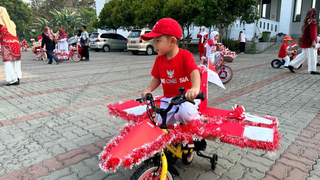 Murid menunjukkan kreativitas melalui sepeda hias bertema kemerdekaan Indonesia.