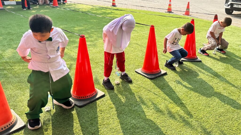 Permainan keseimbangan melatih konsentrasi, koordinasi tubuh, dan keberanian murid dalam suasana perayaan kemerdekaan.