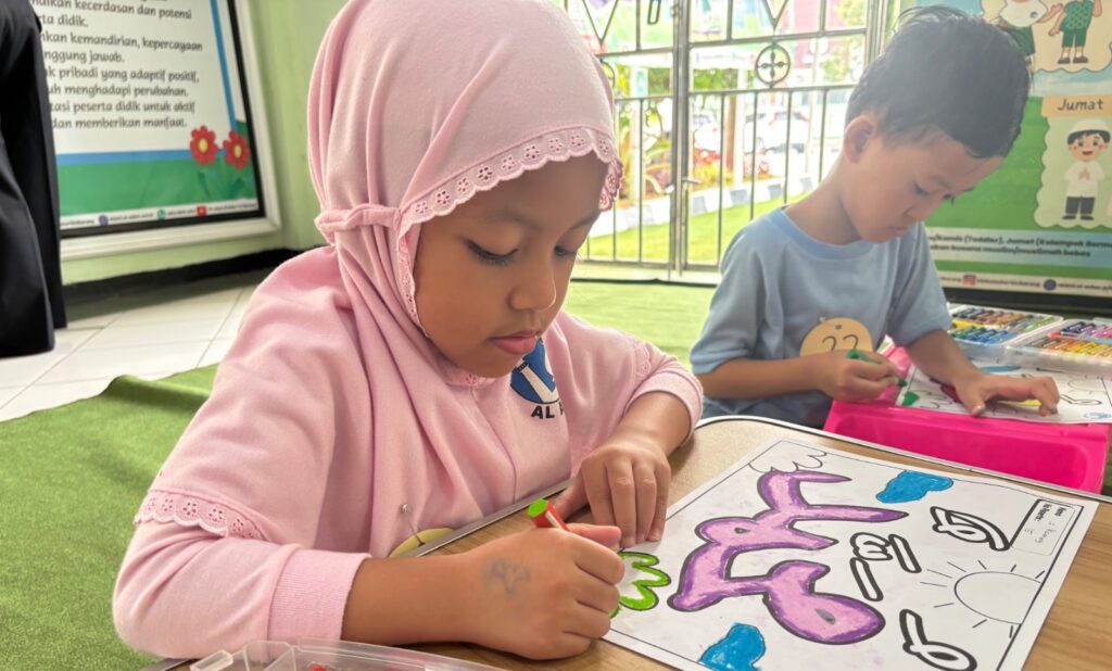 Murid TKIA 12 melakukan lomba memindahkan air dengan spons.